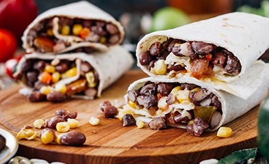 Black bean burritos on a wooden serving platter