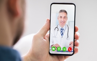 Man holding phone, in video call with healthcare provider