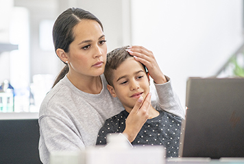 Mom holding son during video visit 
