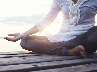 Woman meditating at sunrise