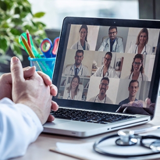 Person on computer video call with multiple healthcare providers