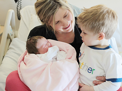 Mom with her newborn baby and older child