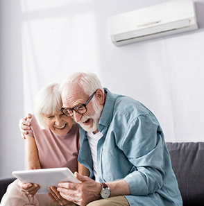 Older couple smiling and looking at tablet