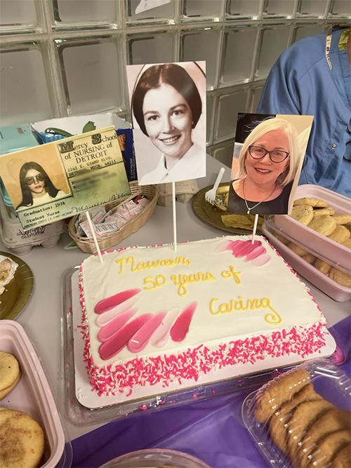Table with photos and cake celebrating Maureen McLeod's 50 years in nursing