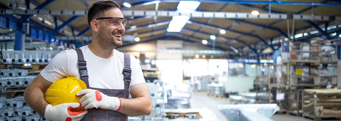 Factory worker with hard hat and safety glasses in warehouse